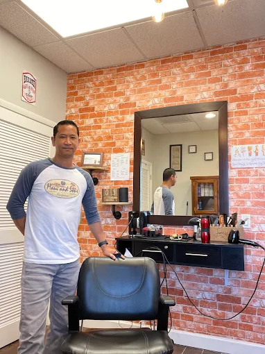 James at the brick-wall barber station inside James Barber Shop and Salon