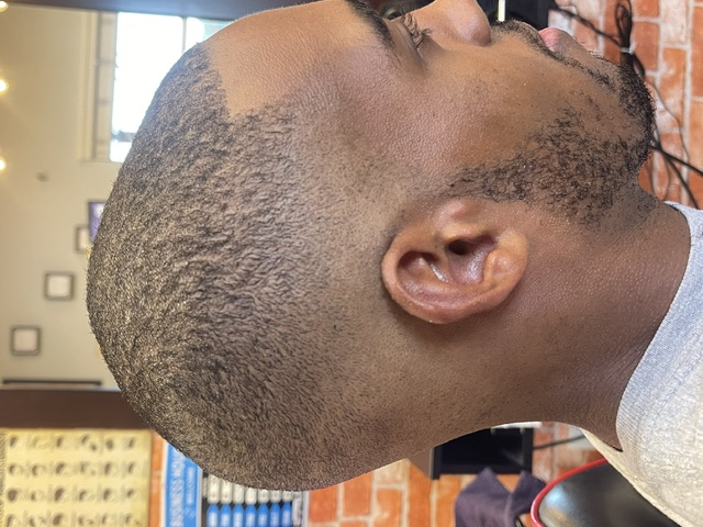 Skin fade haircut finished at the brick-wall station